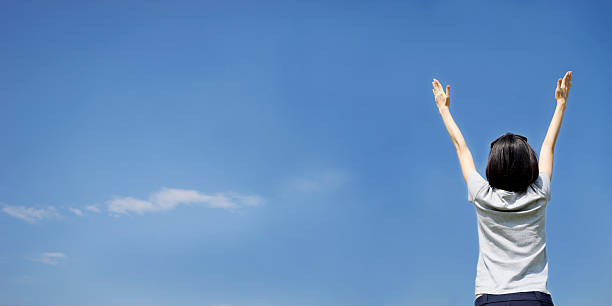 istock female with arms out spread standing outdoors 496773036