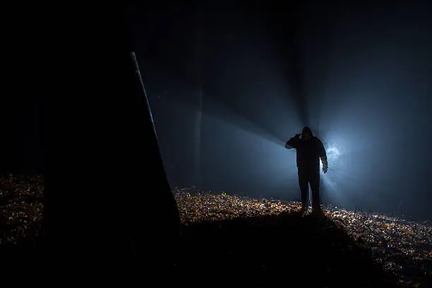 Photo of suicide people in the dark forest, gun in hand.