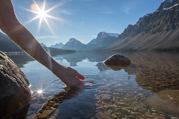 istock Human hand cupped to catch fresh water from mountain lake 496775002