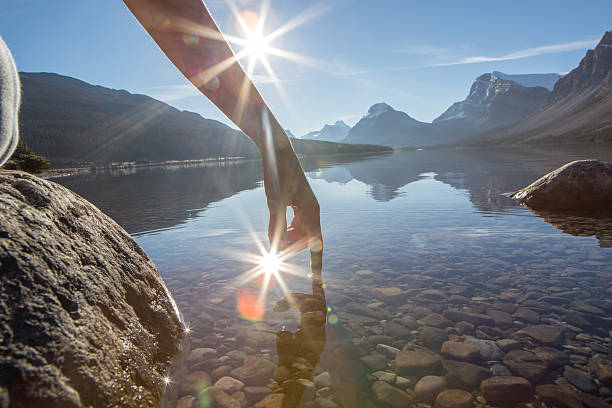 istock Finger touches surface of mountain lake 496775438