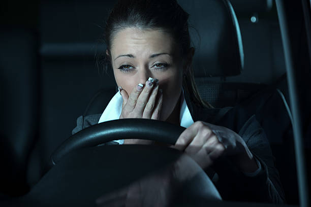 Distracted driving at night Distracted exhausted woman driving a car late at night. Distracted stock pictures, royalty-free photos & images