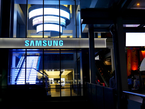 Bangkok, Thailand – November 10, 2015: Exterior view of a Samsung shop in the Siam Square area of Bangkok, Thailand. People walk around the area. The picture is taken from the walkway of sky train station.