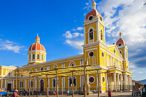 Facade of stone Spanish colonial Catholic church on the street in the historic district of Granada..