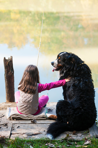 Cute little girl with her dog fishing together