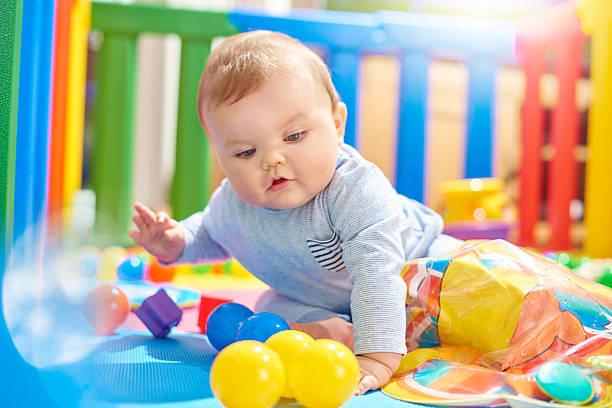 istock Young baby boy playing with plastic balls in his playpen 496777644