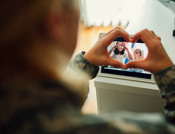 Military Mom Talking With Her Children Over Tablet. Military Mom talking with her children over digital tablet. Using modern technologies and communication to talk to her kids. Mother and children making heart shape with fingers and mother touching screen. Shot with Canon EOS 5Ds military photos stock pictures, royalty-free photos & images