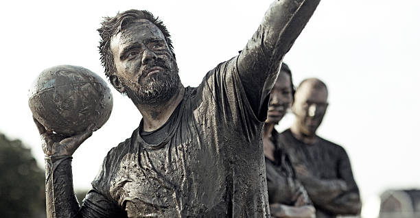 istock covered in mud rugby player with ball 496789380