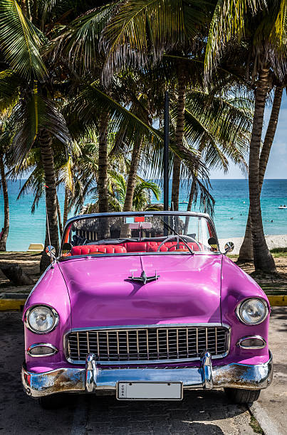 coche clásico rosa estadounidense que estacione en la playa en cuba - varadero beach fotografías e imágenes de stock