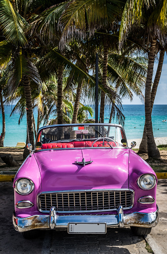 Pink american classic car parked on the beach in Cuba.