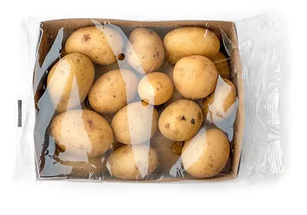 Young potatoes in the box with foil on white