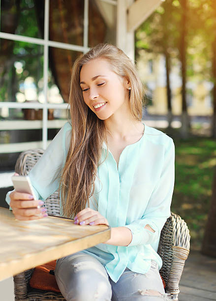 istock Happy pretty smiling woman using smartphone in cafe 496792666