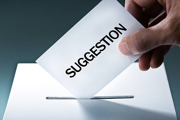 Hand Inserting Suggestion into Suggestion Box stock photo