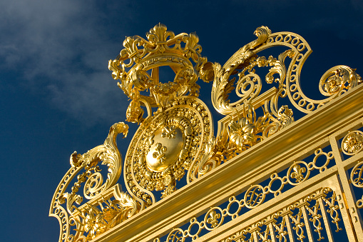 Paris, France - January 2, 2010: Fragment of Entrance gates to the Versailles Palace (Chāteau de Versailles) on a sunny summer day. The Versailles is a royal palace in Versailles which is a suburb of Paris, some 20 kilometres southwest of the French capital.