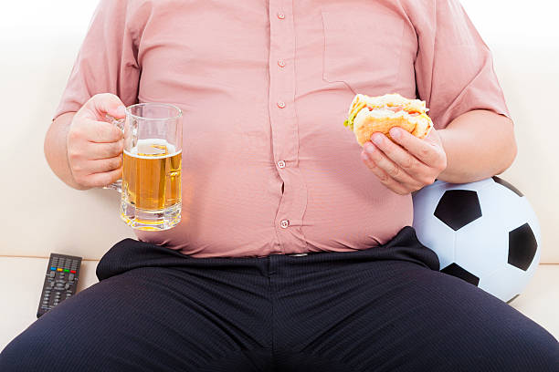 gordura homem de negócios comer alimentos e cerveja e sentado no sofá - remote fat overweight dieting imagens e fotografias de stock