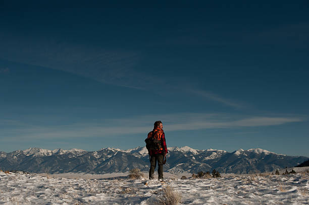 男性の上に立つスノーイー Ridge 、ハンティングの山々 ストックフォト