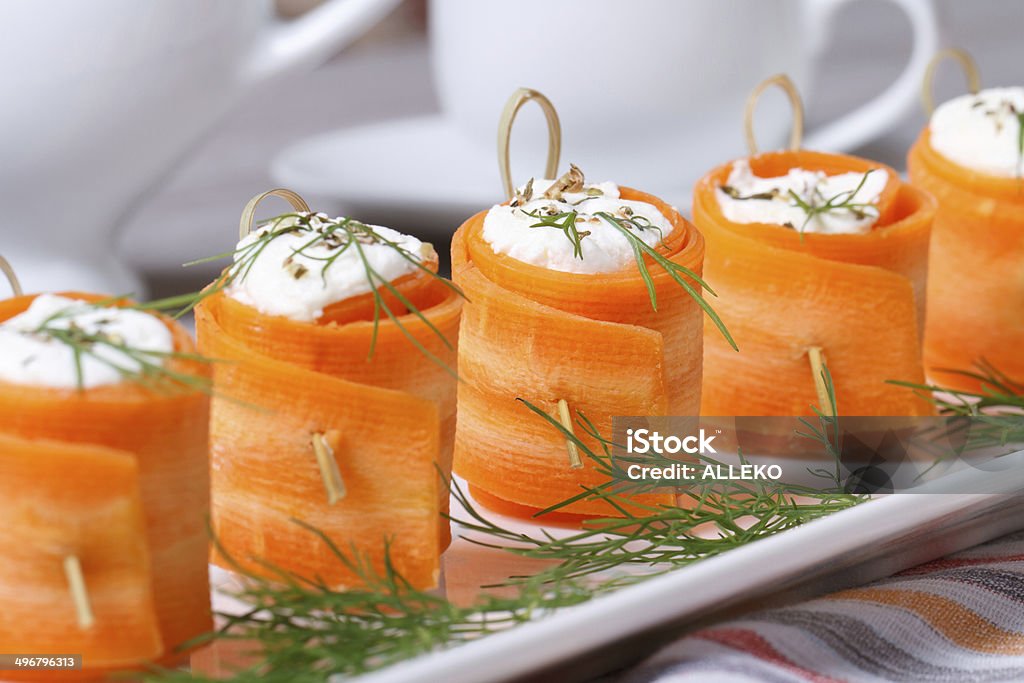 appetizer of fresh carrot rolls with cream cheese Unusual appetizer of fresh carrot rolls with cream cheese and dill on the table. horizontal. Appetizer Stock Photo