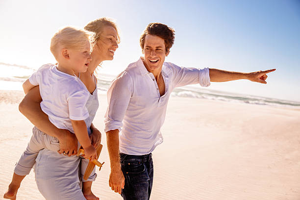 istock Father showing family something on beach 496796709