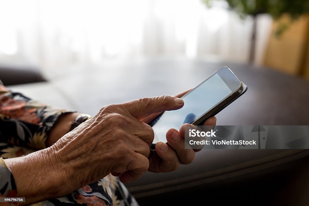 Closeup of old woman hands holding mobile phone Old woman hands with mobile phone, closeup shot Senior Adult Stock Photo