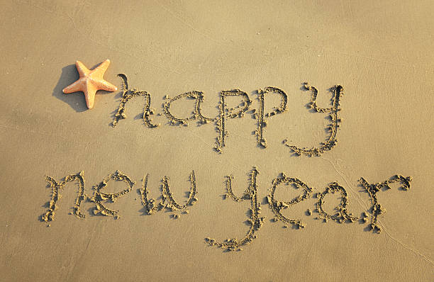 istock happy new year written in the sand 496797629