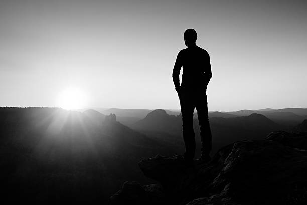 istock Alone slim tourist on rock empire is watch o Sun 496798644