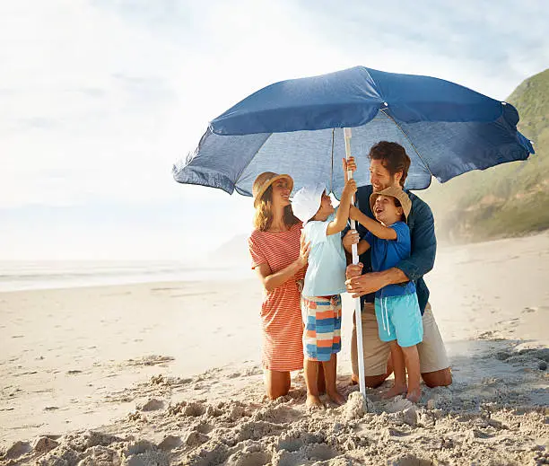 Shot of a happy young family setting up a beach umbrellahttp://195.154.178.81/DATA/i_collage/pu/shoots/784348.jpg