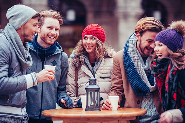 istock Friends having hot drinks outdoors in winter city. 496801064