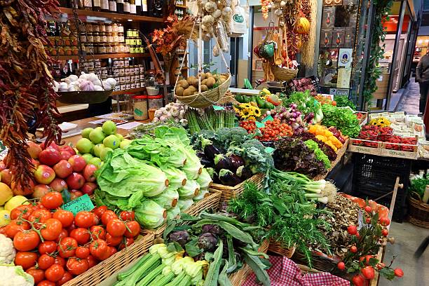 Florence, Italy- June 3, 2011: Baskets and boxes of fresh tomatoes and squash blossoms at a sidewalk produce stand in Florence.
