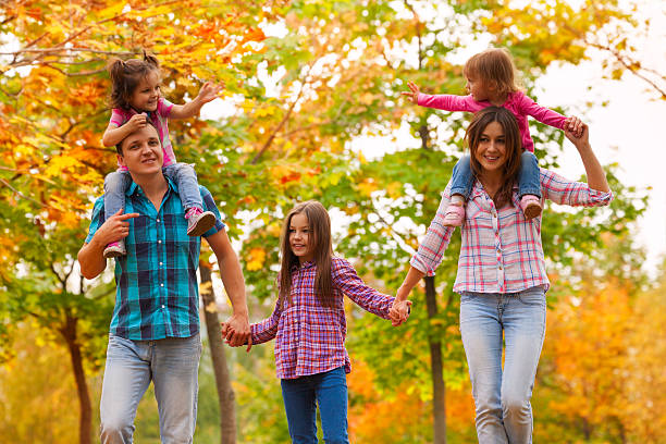 istock Mom walk with kids in the autumn maple forest 496803436