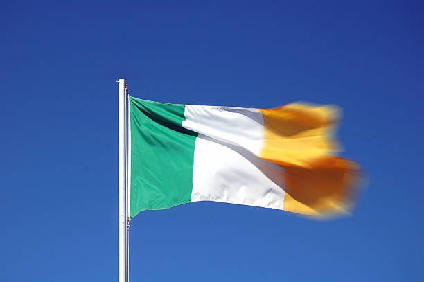 istock Irish flag  flying against a dark blue sky showing movement 496803514