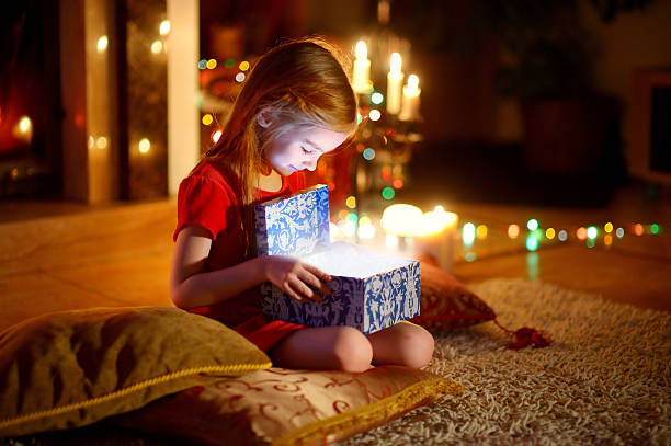 маленькая девочка, открытие волшебный рождественский подарок - dark little girls child happiness стоковые фото и изображения