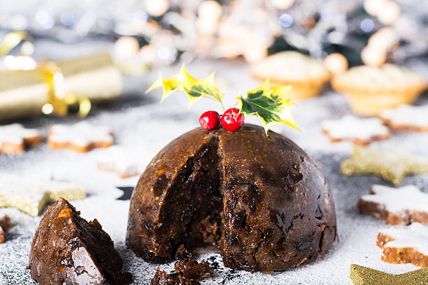 Christmas Pudding and mince pies Christmas Pudding, mince pies and Christmas cookies. Christmas scene and decorations in the background. christmas pudding stock pictures, royalty-free photos & images