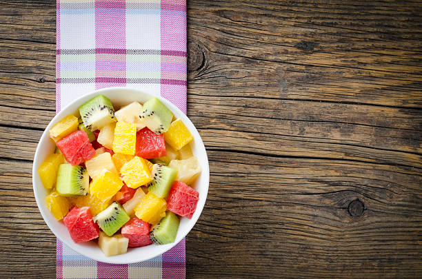 salade de fruits frais sur une table en bois - banane vu de dessus nappe photos et images de collection