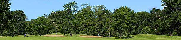 istock Wide panorama image of golf course, bunkers, trees, blue sky 496813711