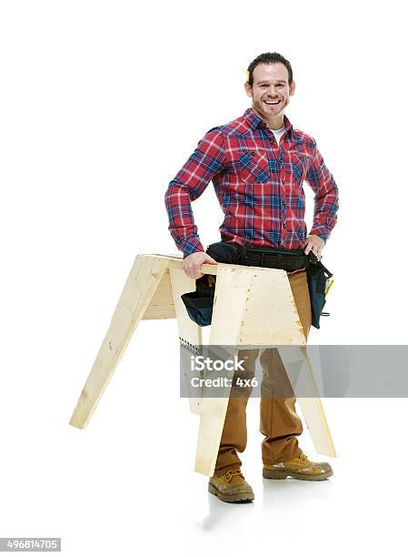 Cheerful Carpenter Holding Sawhorse Stock Photo - Download Image Now - Carpenter, Cut Out, Workbench
