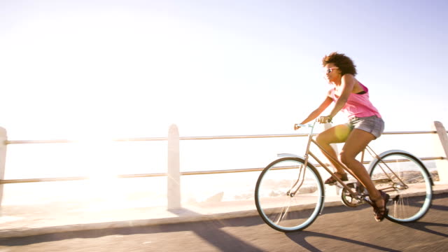 teenage girl riding her bike near beach