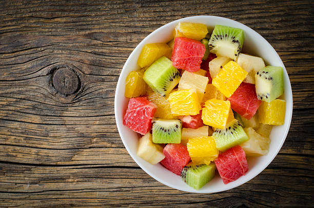 Fresh fruit salad on wooden table stock photo