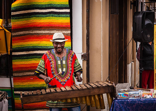 Colombia - Black Marimba player on Plaza Usaquén. Bogota, Colombia - October 25, 2015: a black Marimba player entertains passers-by on Plaza Usaquén, in the capital city of Bogota in Colombia, South America. He is playing on a traditional Marimba and is wearing an Aguadeño hat. Photo shot in the subdued light of a cloudy Sunday afternooon; horizontal format. marimba stock pictures, royalty-free photos & images