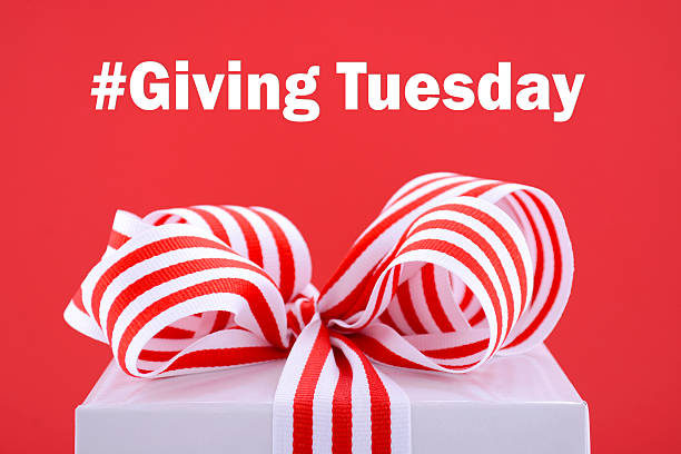 Red and white Giving Tuesday gift. Red and white gift symbolic for Giving Tuesday with sample text on bright red and white background. giving tuesday stock pictures, royalty-free photos & images