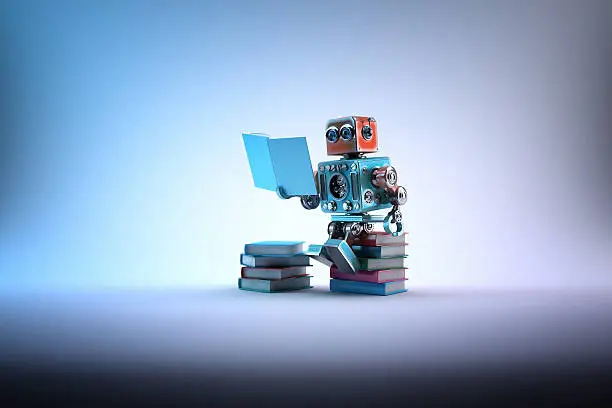 Photo of Robot sitting on a bunch of books. Contains clipping path