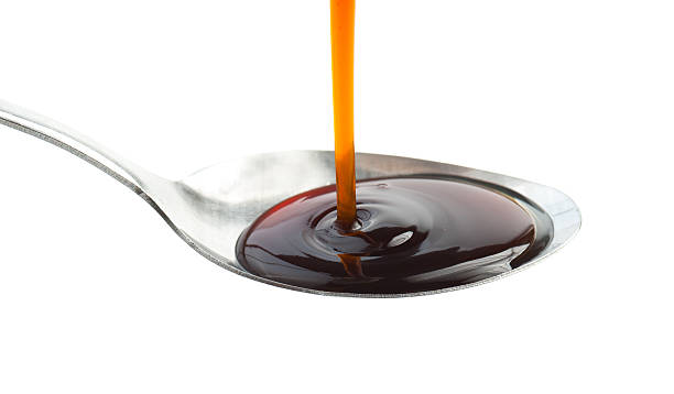 istock Pouring Soy Sauce on spoon isolated on white 496822576