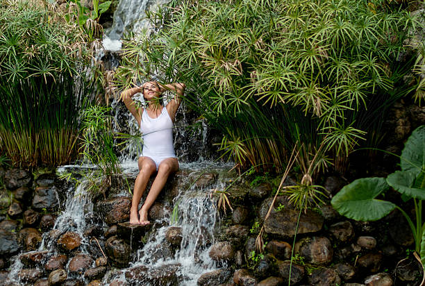 Young woman swims in waterfall in Soca Valley