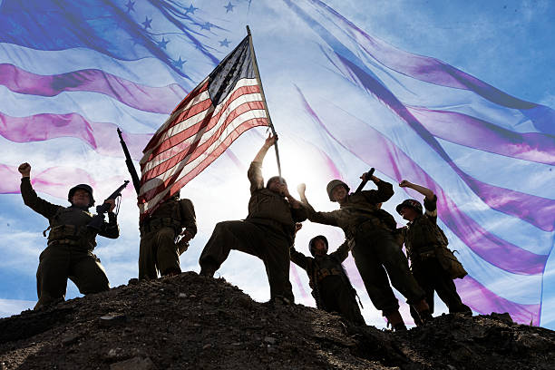 US Army Soldiers on hill with American Flag War World ll solders standing on a hill holding and carrying the American flag. Iwo Jima Concept photo. us marine corps stock pictures, royalty-free photos & images