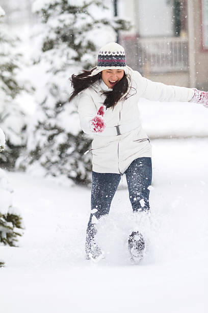 Young Chinese Woman Playing In Snow stock photo