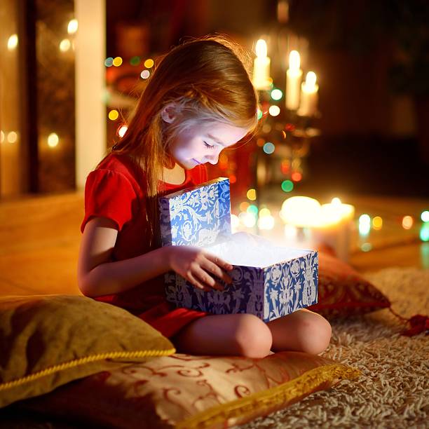 istock Little girl opening a magical Christmas gift 496828518