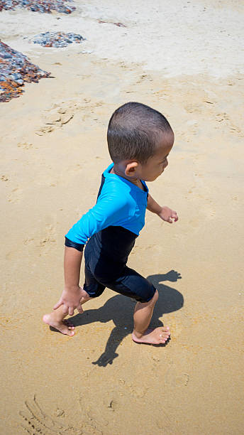 istock Young kid wearing swimsuit running on a sandy tropical beach 496830835