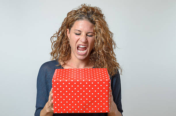 crier brunette femme tenant rouge boîte de cadeau - beautiful red hair curly hair human hair photos et images de collection