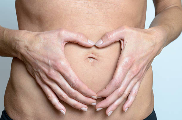 istock woman making heart sign on her belly 496831938