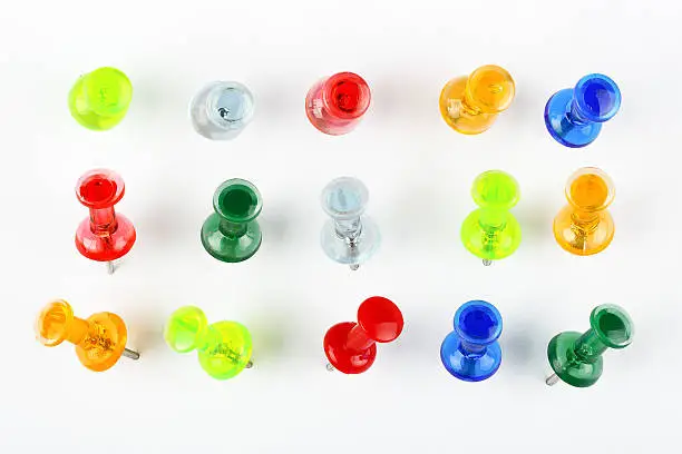 variety of colorful pushpins pinned on white paper