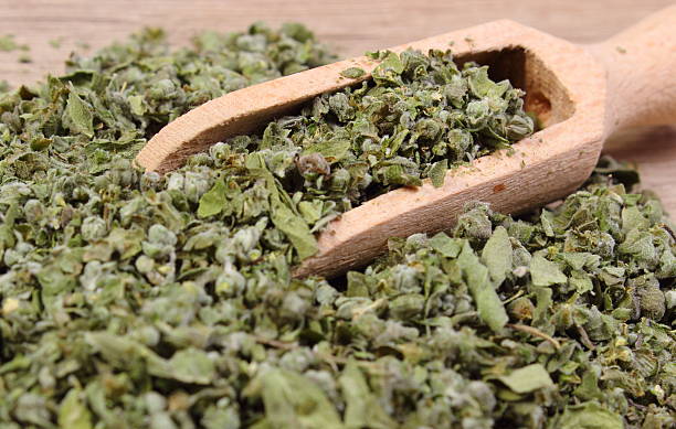 istock Dried marjoram with spoon on wooden background 496833248