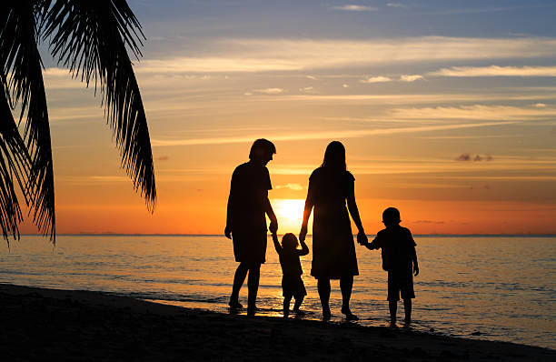 istock happy family with two kids walking on sunset beach 496833292